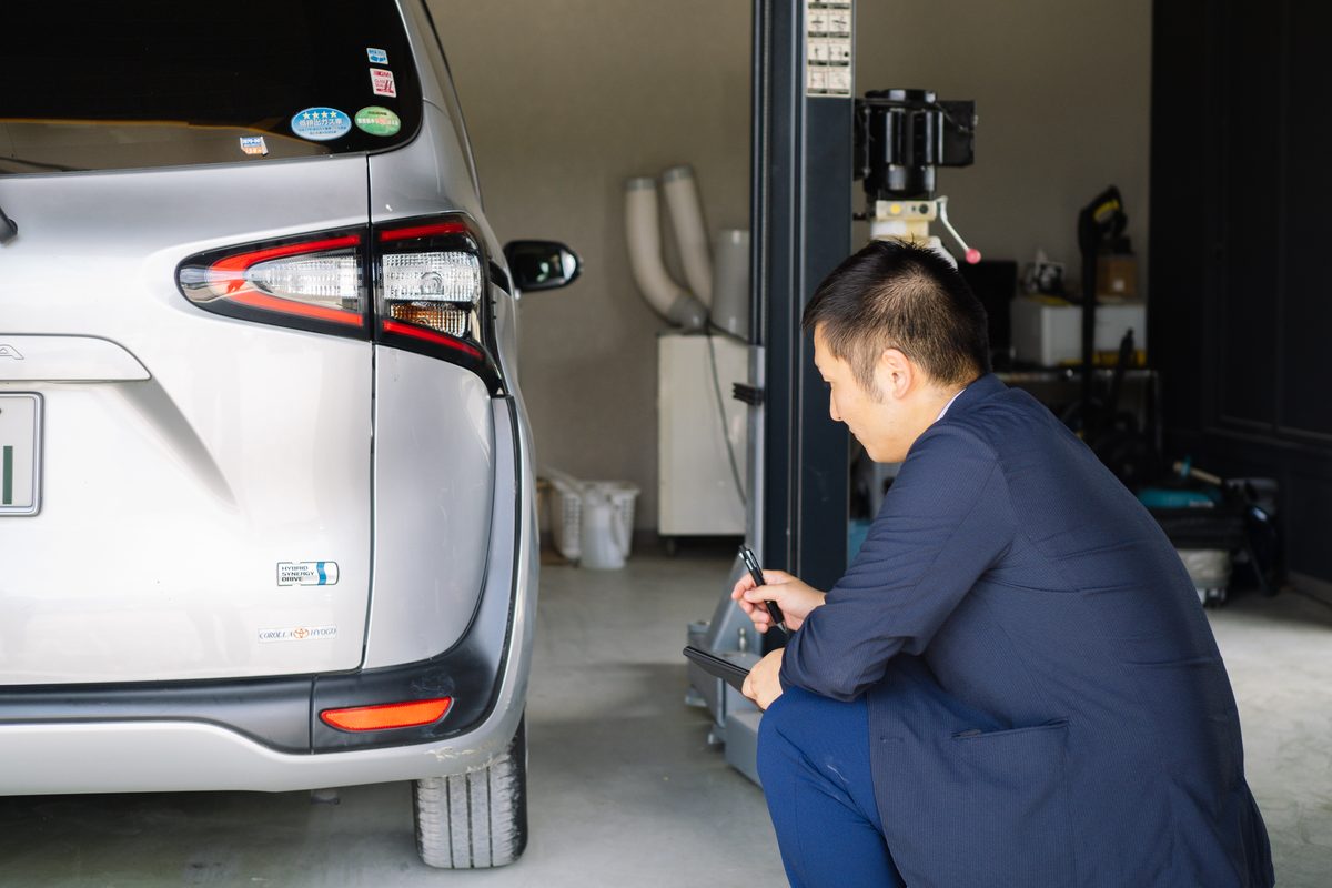 スーツ姿のスタッフが車の点検をするカーラボの受付対応